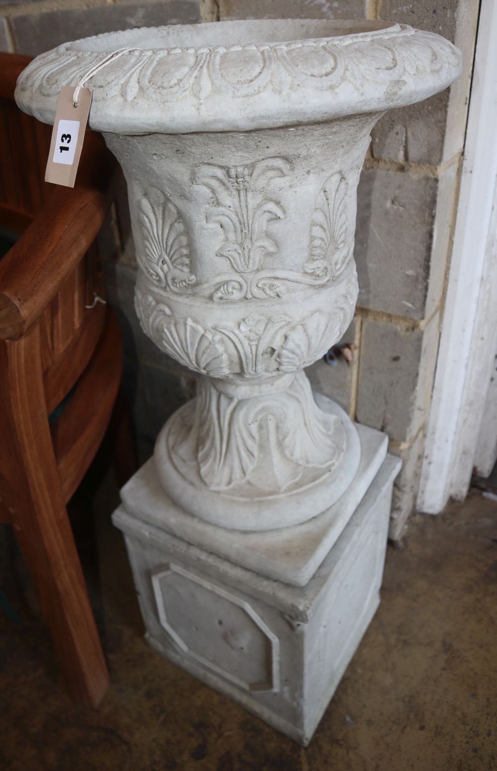 A reconstituted stone campana garden urn on stand, Diameter 40cm, H.88cm